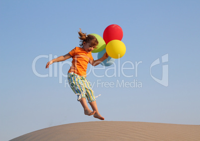 happy little girl jumping with balloons