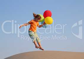 happy little girl jumping with balloons