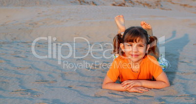 little girl lying on sand