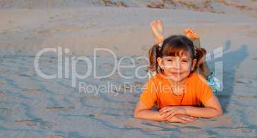 little girl lying on sand
