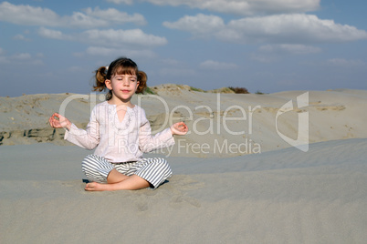little girl meditating in desert