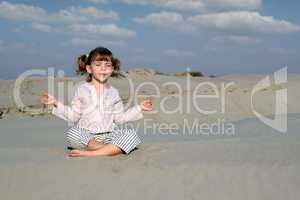 little girl meditating in desert