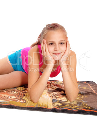 Closeup of young girl lying in bathing suit on floor.