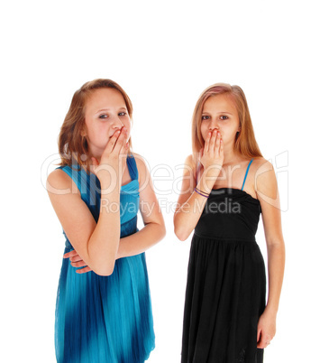 Two girls with hands over there mouth.