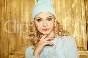 Gorgeous young woman with blond ringlets in a green knitted winter outfit