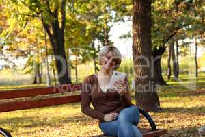 beautiful woman with tablet in park