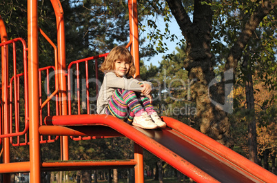 little girl sitting on slide