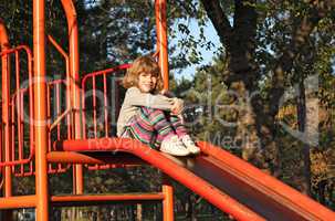 little girl sitting on slide