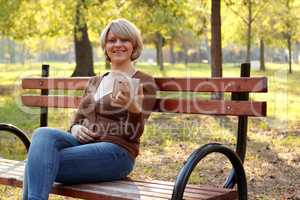 beautiful woman sitting in park and play with tablet