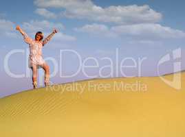 beautiful woman with thumbs up standing on desert dune