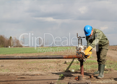 oil worker closes the valve