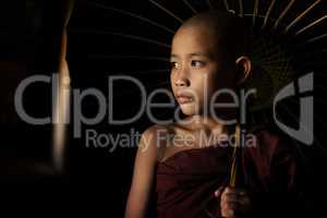 Buddhist novices holding umbrella