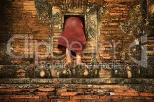 Buddhist novice monk climbing into monastery