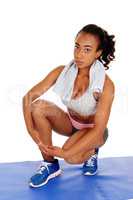 Beautiful woman crouching in sportswear.