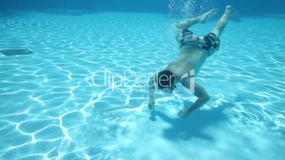 Teenager floats under water in pool