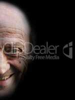 Portrait of a smiling elderly man on black background