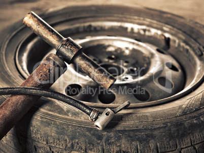 old hand-pump and car wheel close-up