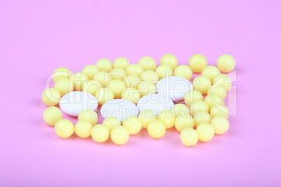 yellow vitamins on pink background