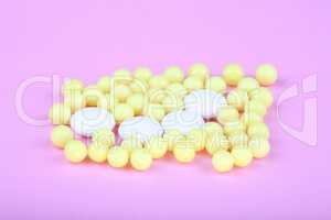 yellow vitamins on pink background