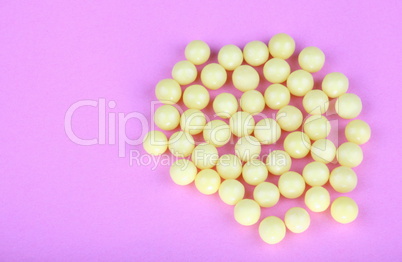 yellow vitamins on pink background