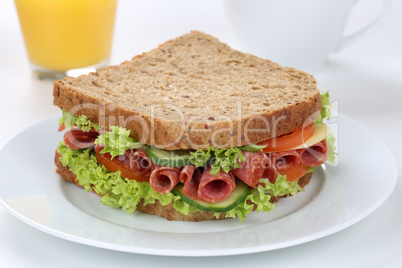 Sandwich Toast zum Frühstück belegt mit Salami und Saft
