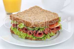 Sandwich Toast zum Frühstück belegt mit Salami und Saft