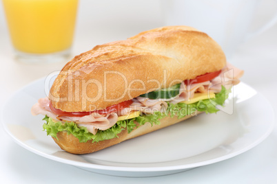 Sandwich Baguette belegt mit Schinken zum Frühstück mit Orange