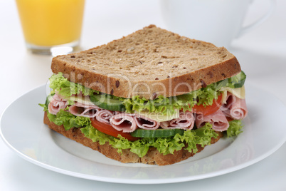 Sandwich Toast zum Frühstück belegt mit Schinken und Saft