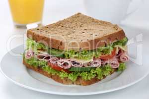 Sandwich Toast zum Frühstück belegt mit Schinken und Saft