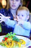 child asks her mother dish with vegetables grilled