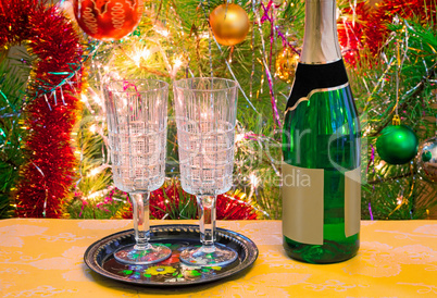 Christmas holiday, wine and glasses near a Christmas fir-tree.