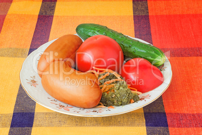 Two big sausages and vegetables on a white dish.