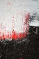 Brushstroke with white,black and red paint  on dusty metal