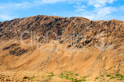 Rocky dry yellow cliff ridge with eroded channels