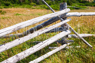 Dry wood log fence corner in long grass