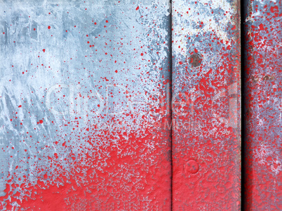 Small part of metal door sprinkled with red paint