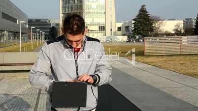 man walks on the street and works on a tablet
