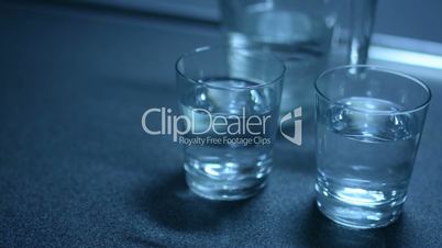 Two glasses filled with water and jug on the kitchen counter