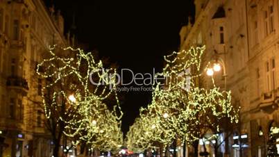 Christmas Parisian street with people, shining trees and cars (Blurred shot) - in night
