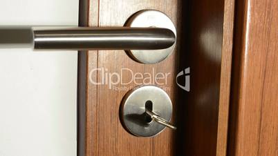 hand (young man) unlocks interior door with key