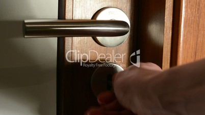 hand (young man) locks interior door with key