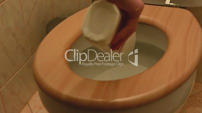 A man cleans a toilet using a disinfectant