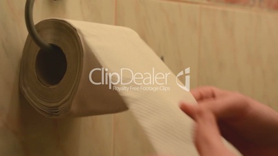 hand (young man) take toilet paper on the toilet