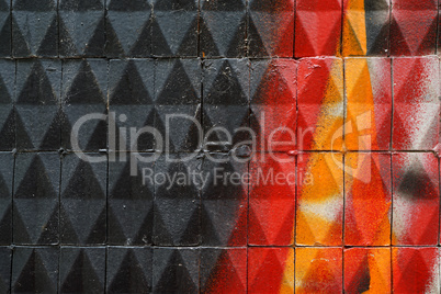 Facade with painted  ceramic triangular tiles