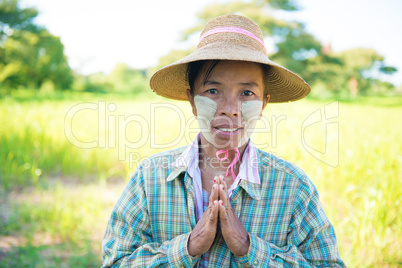Traditional mature Asian female farmer greeting