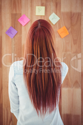 Rear view of hipster woman looking post-it