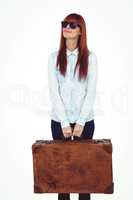 Smiling hipster woman holding suitcase