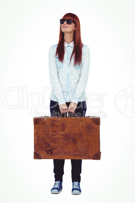 Smiling hipster woman holding suitcase