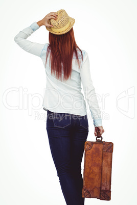 Rear view of hipster woman holding suitcase