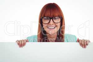 Smiling hipster woman behind a white card